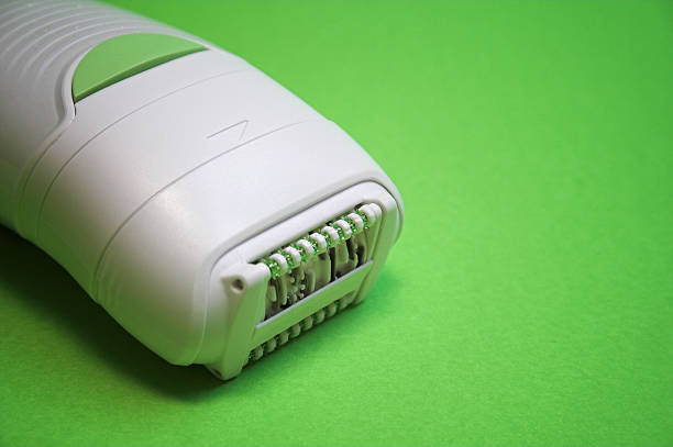 Women electrical depilator isolated on green Women electrical depilator isolated on green. epilator stock pictures, royalty-free photos & images