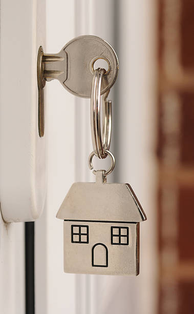 istock Silver house keychain attached to a door key 173035475