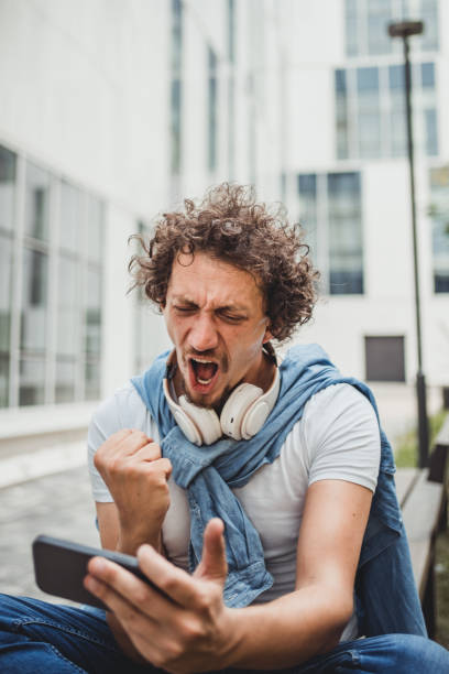 istock Smiling middle-aged man playing video games on his smartphone 1730370309