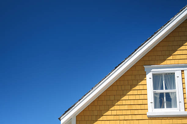 The architectural detail of a roofline on a home Architectural detail of an old yellow house on a sunny day.  detached house stock pictures, royalty-free photos & images