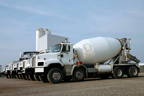 Several cement trucks lined up in a parking lot