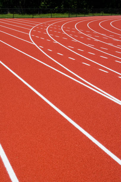istock Red orange running track with white lane lines 173038590