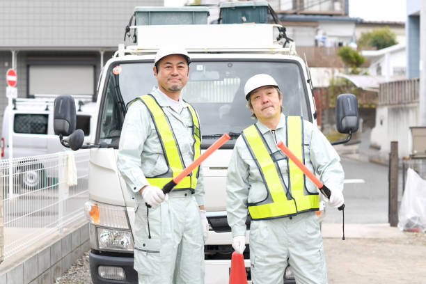 istock Middle-aged men working as traffic guides holding guide lights in front of trucks 1730396531