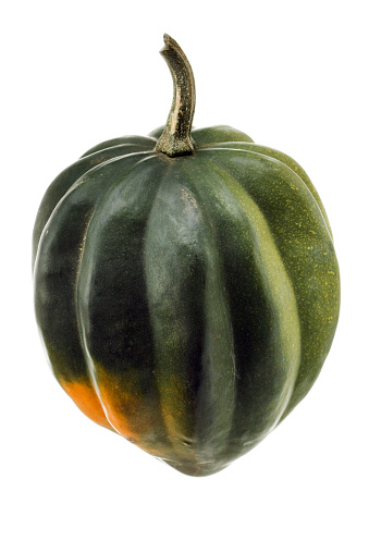 An acorn squash, a raw, fresh, green autumn vegetable with orange food inside, isolated on a white background.