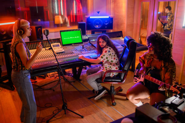 istock Recording session with three musicians and sound technician in music studio. 1730408053