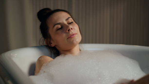 istock Sensual model enjoying spa routine at evening bathroom. Calm woman touching body 1730408575