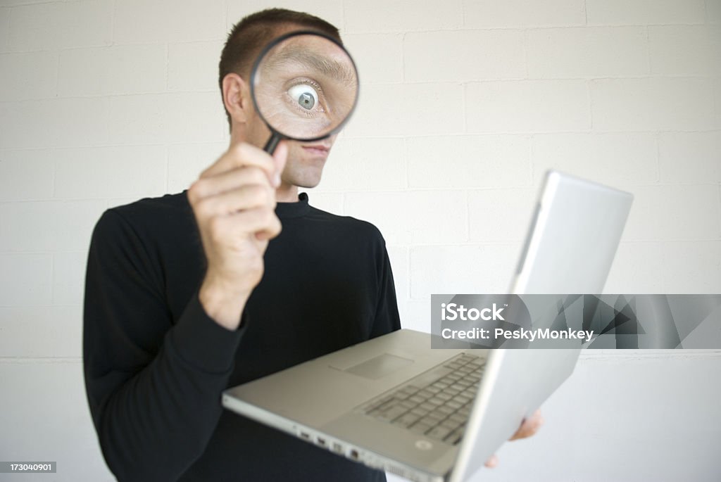 Snooping Computer Spion überrascht Auge in Lupe mit Laptop - Lizenzfrei Humor Stock-Foto