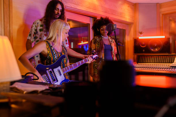 istock Three multicultural musicians preparing for recording session in music studio. 1730409119