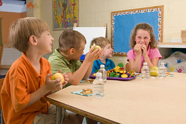 Classroom snack Students take a break for a healthy snack. food elementary student healthy eating schoolboy stock pictures, royalty-free photos & images