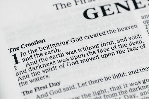 Opening verse of the King James Version of the Bible.  In the beginning God created the heaven and the earth.  Desaturated color.  Very Shallow Depth of Field, focus on the word beginning.