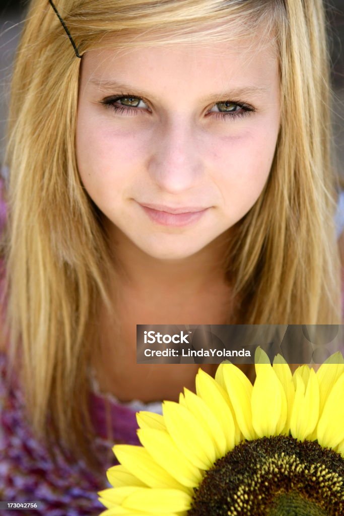 Teen and Sunflower Pretty fourteen-year-old girl and a large sunflower. Focus is on her eyes. Please view my other child and sunflower images. 14-15 Years Stock Photo