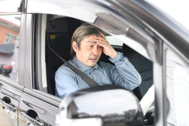 istock Middle-aged Asian man driving a car with an anxious expression 1730436259