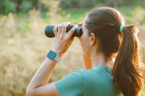 Woman looking through binoculars at the nature of the Pantanal in Brazil