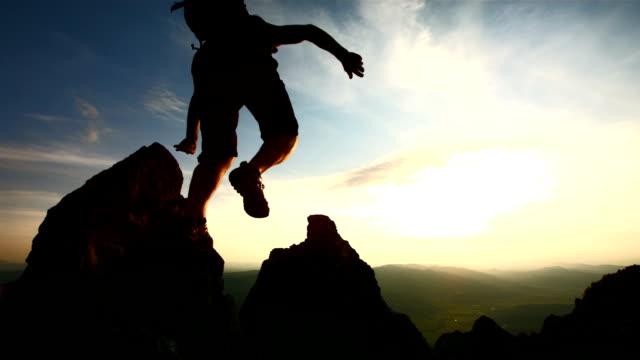 HD Super Slow-Mo: Hiker Jumping Over Rocks At Dusk