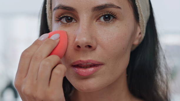 istock Pov model applying foundation indoors. Portrait lady using makeup visage sponge 1730464118