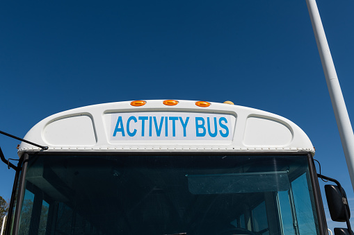 Close-up view of an activity bus or school activity with lights and a blue sky background.