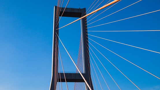 Bridge tower design with strong cables and blue sky background