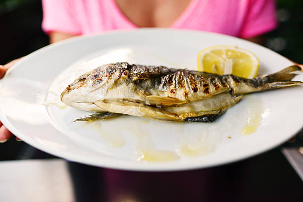 Grilled Whole Sea Bream with lemon on a plate