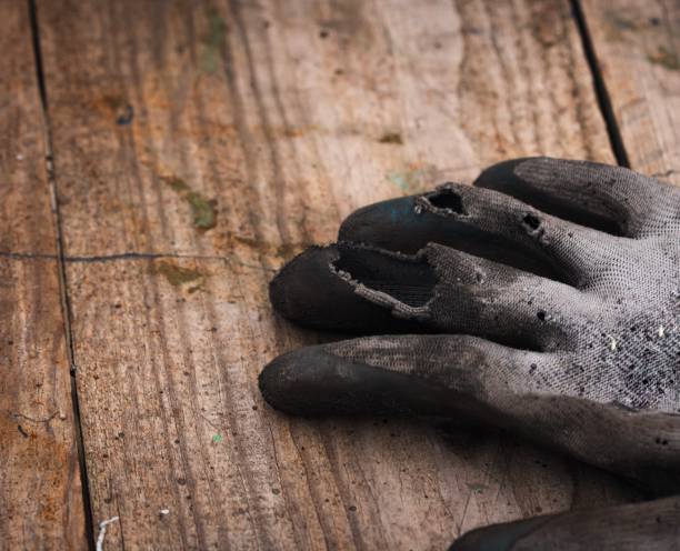 istock Old worn-out work gloves lying on the board 1730555916