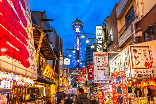 October 8, 2023: Street view of Shinsekai and Tsutenkaku tower in Osaka, Japan. Shinsekai, lit. New World, is a retro area developed before the war and then neglected in the decades afterwards.