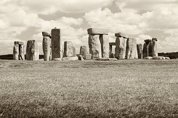 A sepia processed Stonehenge under fluffy clouds.