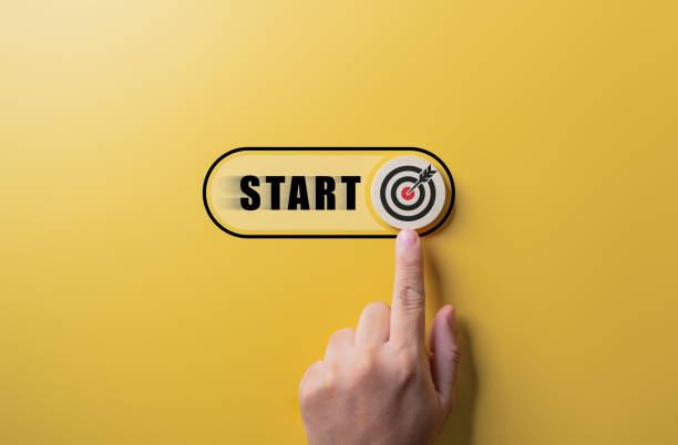Hand sliding wooden toggle button with arrow dartboard to start launch project, Start business with focusing objective target and goals concept. Start-up idea or Business expansion.