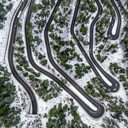 Aerial view of a car serpentine on a mountain. Road to La Thuile village and ski area. Snowy mountain serpentine in Aosta valley in Italy.