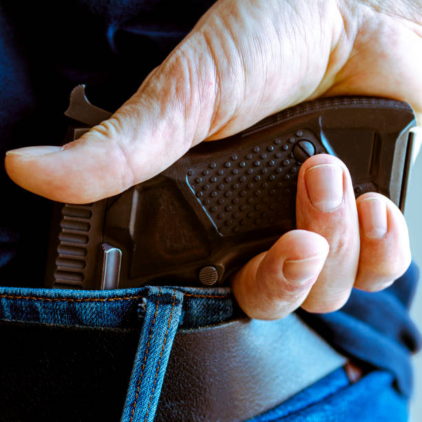 istock A person is hiding a handgun under the denim belt. 1730686459