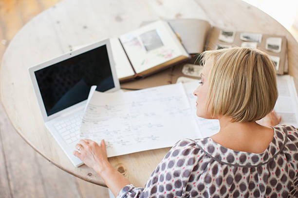 mujer en la tabla mirando genealogical árbol - árbol genealógico fotografías e imágenes de stock