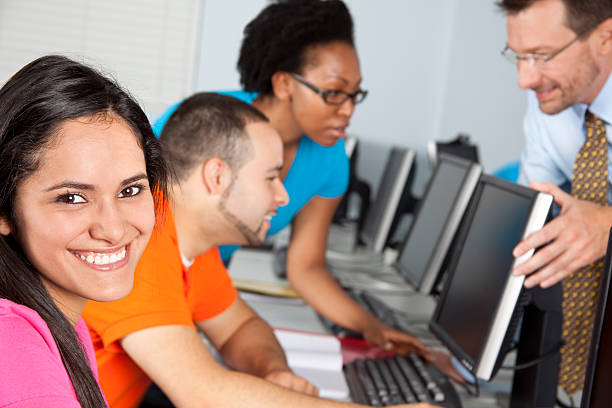 istock Young adult students in college computer lab with instructor 173072417