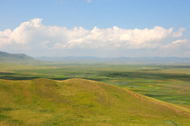 istock Parallel rows of rocky formations running down the slope of a gentle hill overlooking a picturesque valley in the mountains under a cloudy summer sky. 1730744094