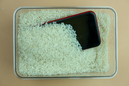Mobile phones is embedded with rice from falling on water. Top view