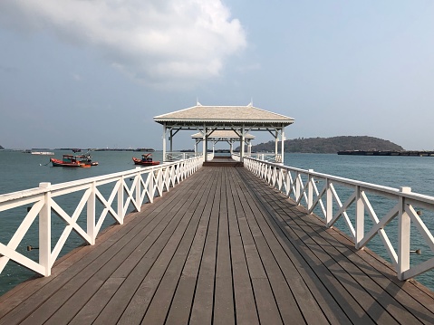 A Wooden Pavilion in the middle of the sea amidst a beautiful sky.