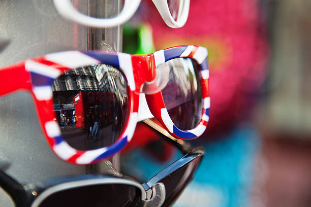 London Union Jack patterned sunglasses with reflected view of an iconic London red bus in the glasses. London Memorabilia stock pictures, royalty-free photos & images