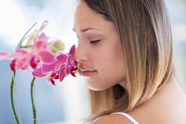 женщина с закрытыми глазами нюхать орхидея - beauty women orchid flower стоковые фото и изображения