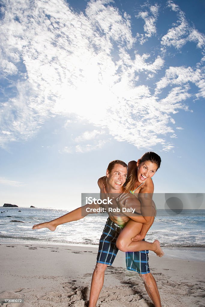 Brincalhão homem dar a namorada Cavalitas na praia - Royalty-free 20-24 Anos Foto de stock