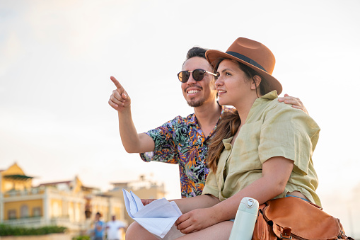 Traveler couple searching the map for famous places and pointing where she should go