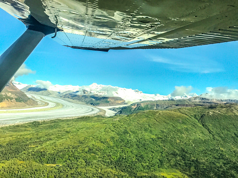 The beauty of Alaska as seen from above. Picture of Alask's Wrangle mountains, with glacial flows and stunning landscapes, from the window of a small airplane. The airplane was flying over the Wrangle Mountains in Interior Alaska.