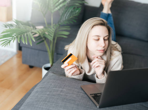 istock Young woman holding credit card and using laptop computer. 1730875451