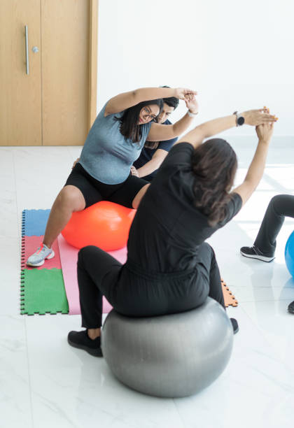 беременная женщина растягивается с мячом для пилатеса - human pregnancy prenatal care relaxation exercise ball стоковые фото и изображения