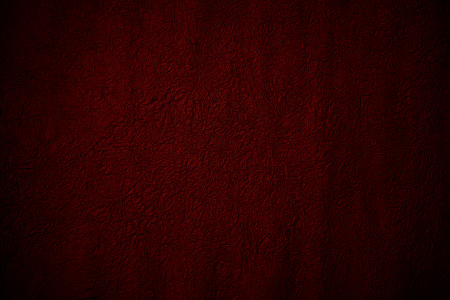 Close-up of red crumpled paper texture background with spot lit.