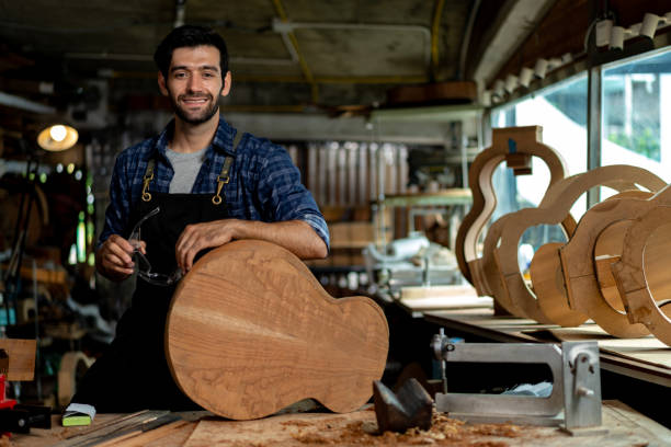 istock Acoustic Guitar Luthier Smiling in Workshop Portrait 1730957092