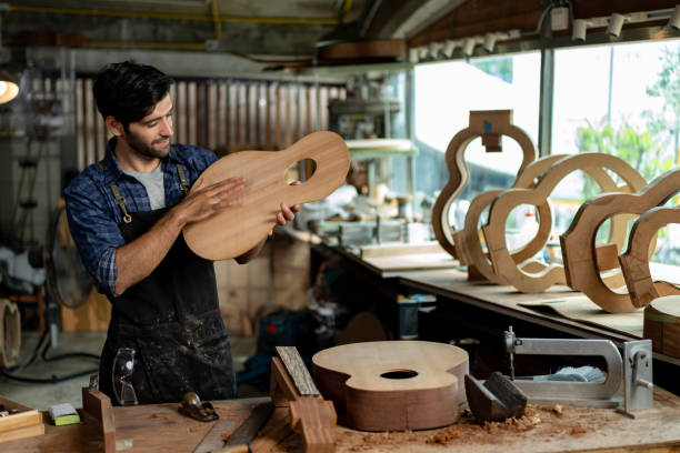 istock Luthier Taps Acoustic Guitar Wood to Check Sound Quality 1730957607