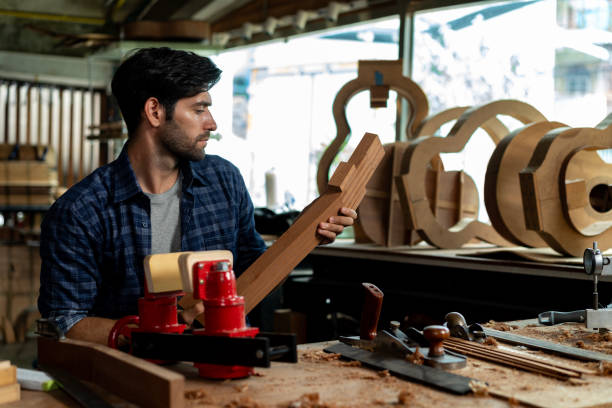 istock Guitar Luthier Examines Wood for Acoustic Guitar Neck 1730957608