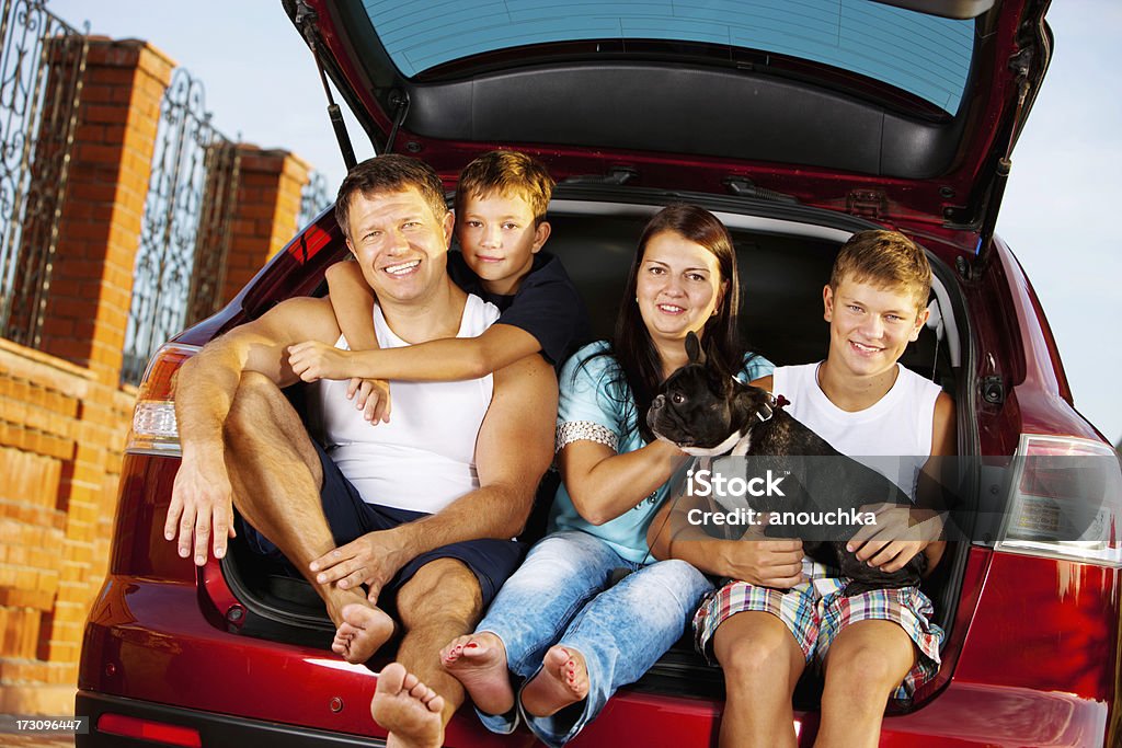 Família feliz com Buldogue Francês em carro pronto para viagem - Foto de stock de Família royalty-free