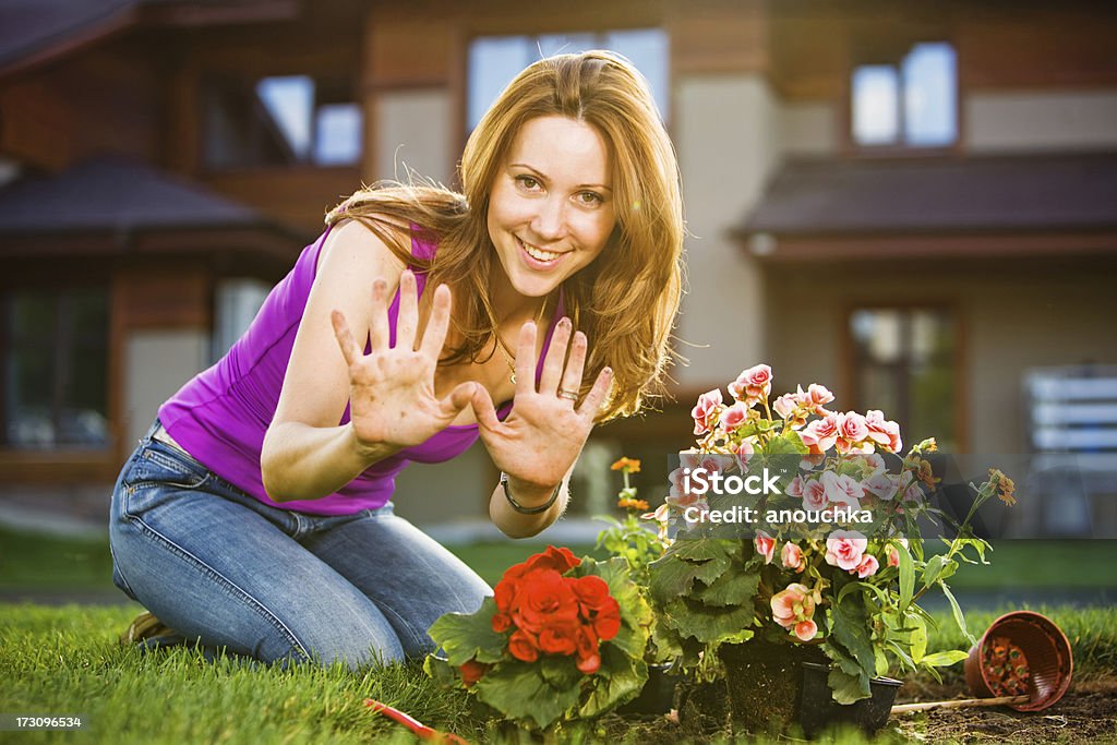 Woman showing her durty hands while planting flowers in garder 30-39 Years Stock Photo