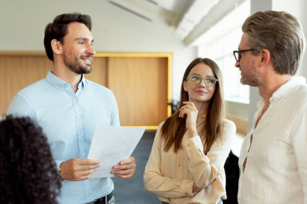 istock Smiling business people, colleagues talking, planning startup, sharing ideas, discussion, working together in modern office. Meeting, teamwork, successful business concept 1730967587