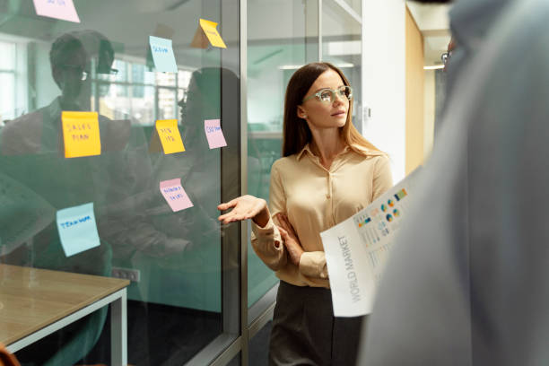 istock Businesswoman wearing stylish eyeglasses using sticky notes, agile methodology for productivity 1730967606