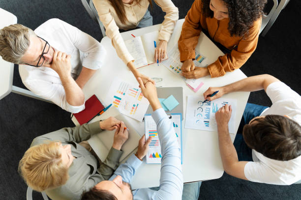 istock Successful businesspeople working together in modern office, sitting at desk, planning startup 1730967621