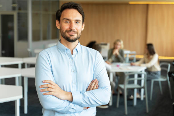 istock Confident smiling salesman with crossed arms working in modern office 1730967637